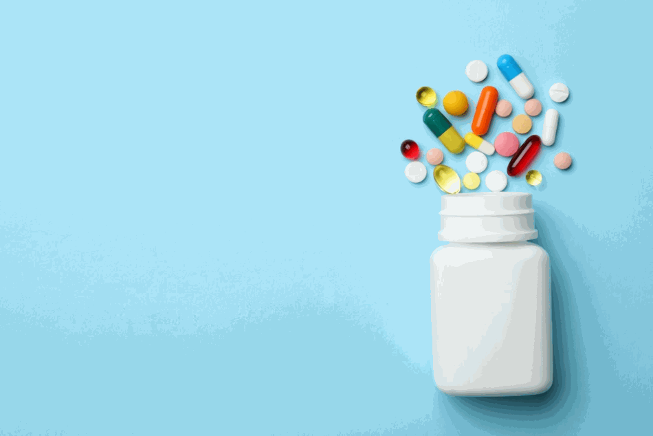 Bottle and Pills Spread Out on Blue Background