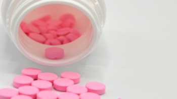 Warfarin Supplement Interactions -- bottle of pink warfarin tablets