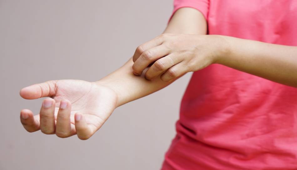 Person in Pink Shirt Scratching Arm