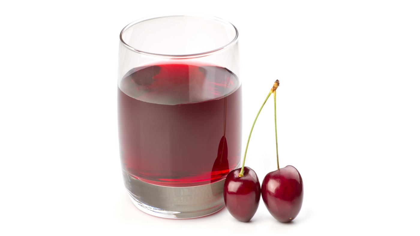 Tart Cherry Benefits -- glass of cherry juice and two tart cherries