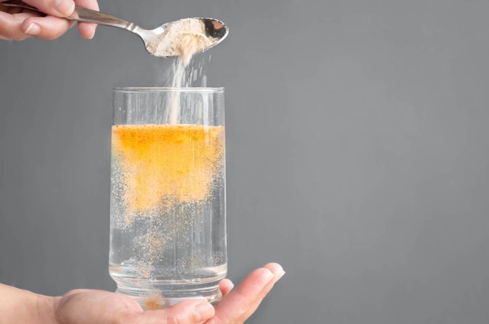 Orange Powder Dissolving in Glass of Water