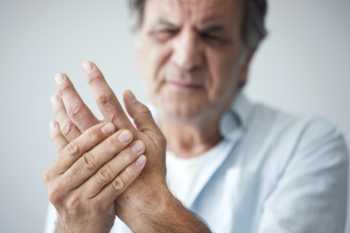 Elderly Man Clutching Fingers Due to Pain