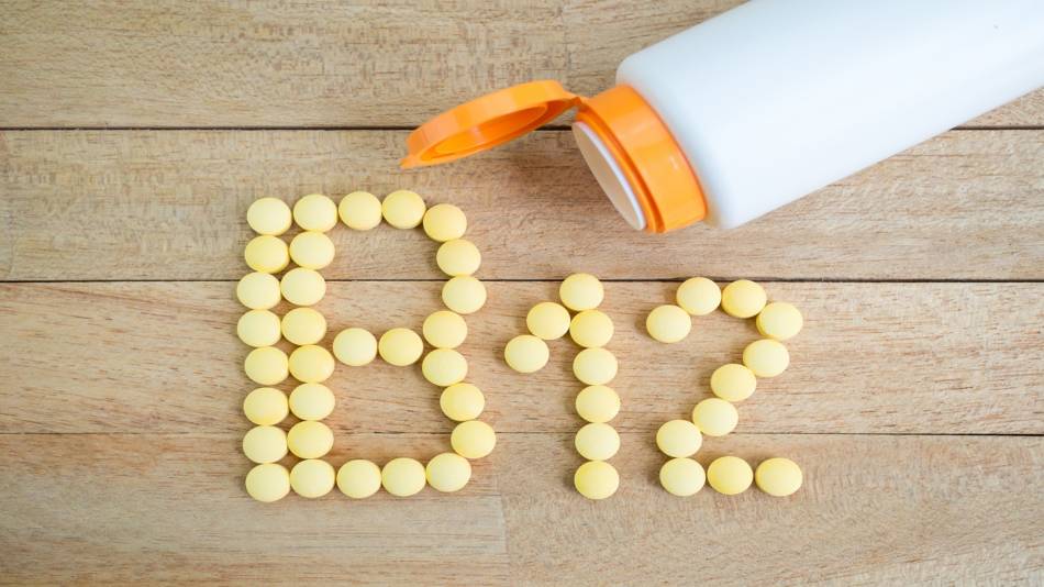 The danger of taking too much vitamin B-12 -- bottle of vitamin B-12 with pills on the table spelling out 'B-12'