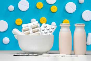 Probiotic Supplements and Bottles Against Blue Background
