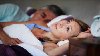 Woman with insomnia awake in bed and having trouble sleeping