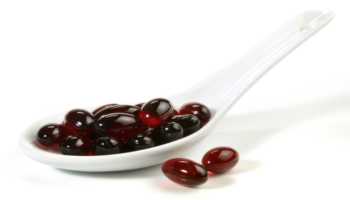 Astaxanthin Pills in White Spoon