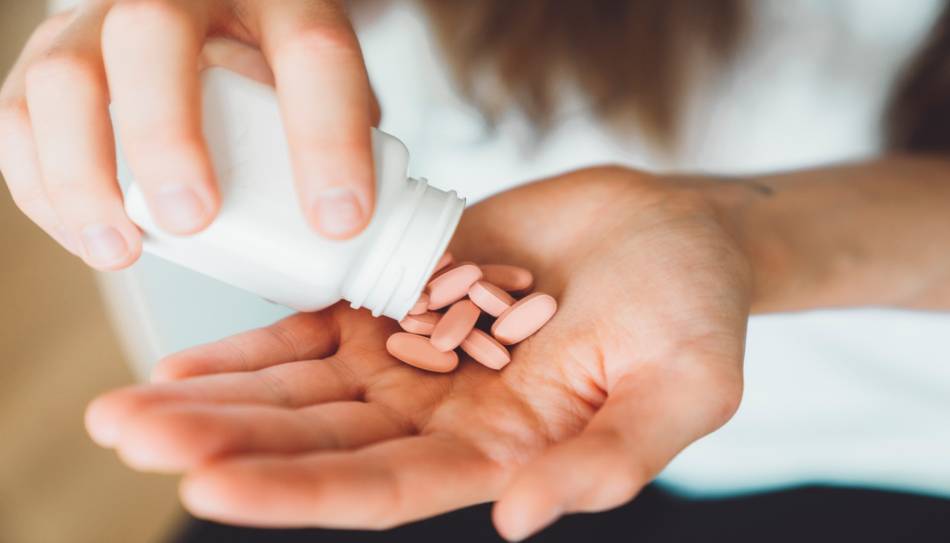 Woman holding vitamins in hand