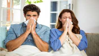 Supplements for Colds: Zinc, Echinacea & More -- Couple with cold, sitting on couch blowing their noses