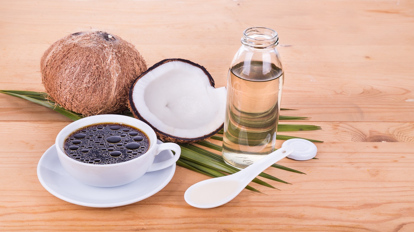 Coconut Oil & MCTs -- Coconuts and coconut oil with coffee cup  