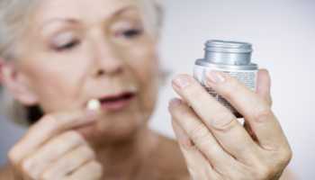 Elderly Woman Reading Supplement Bottle