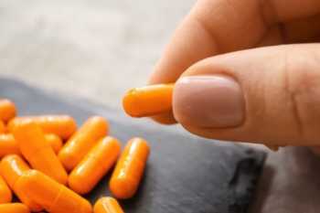 Curcumin Tablet Close Up with Pile of Tablets in Background