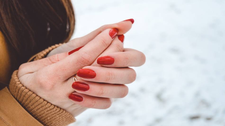 Supplements for Raynaud's Phenomenon -- woman standing outside in snow, with cold, red hands
