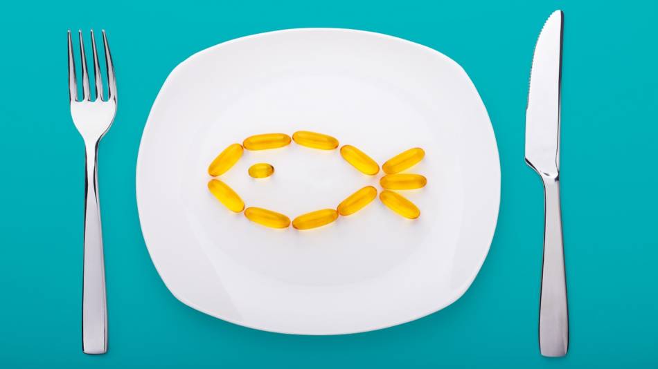 Best Way to Take Fish Oil -- fish oil capsules on plate with fork and knife