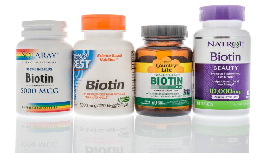 Biotin Supplements for Hair and Nails -- woman looking at hair and nails in mirror