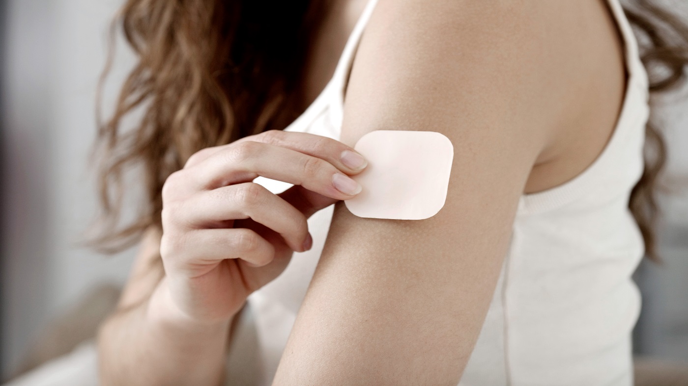 Vitamin Patches -- young woman with vitamin patch on arm