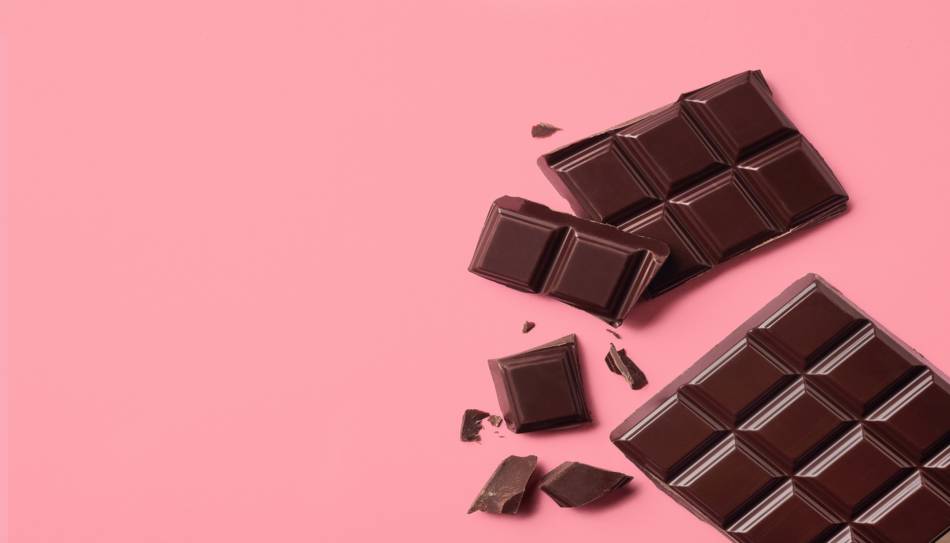 Broken Bar of Chocolate on Pink Background
