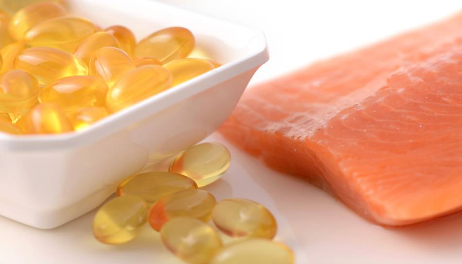 Fish Oil Capsules and Salmon on White Table