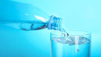 Microplastics in water, plastic bottle of water pouring water into glass