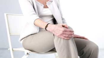 Curcumin and Boswellia for Knee Pain -- Older woman with osteoarthritis holding knee in pain