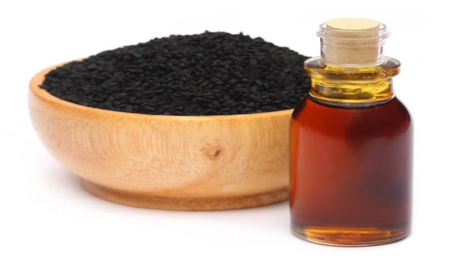Black seed oil benefits -- bowl of black cumin seeds and bottle of oil