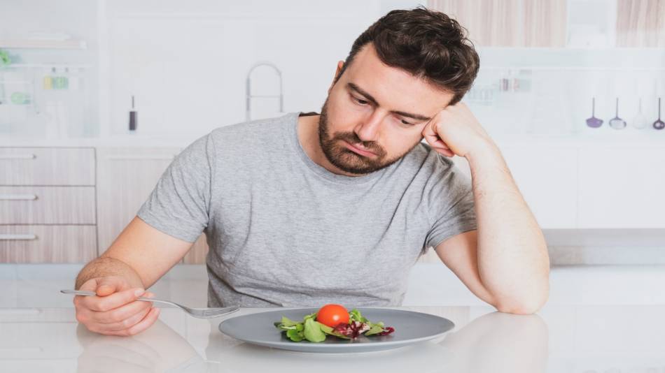 Vitamin Deficiency, Supplements and Loss of Taste? -- man with salad looking disinterested, unhappy
