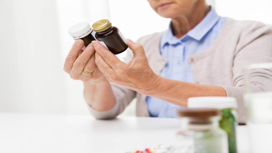 How to compare supplement labels -- woman looking at the labels of two supplement bottles