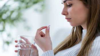 Lead in Supplements & Foods -- concerned woman looking at pill 