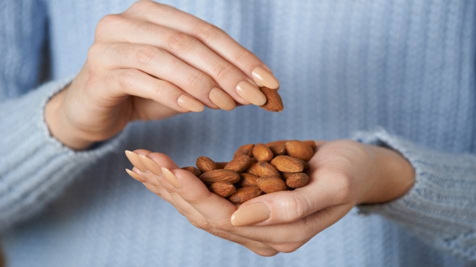 Eating Almonds to Reduce Wrinkles? -- woman with handful of almonds