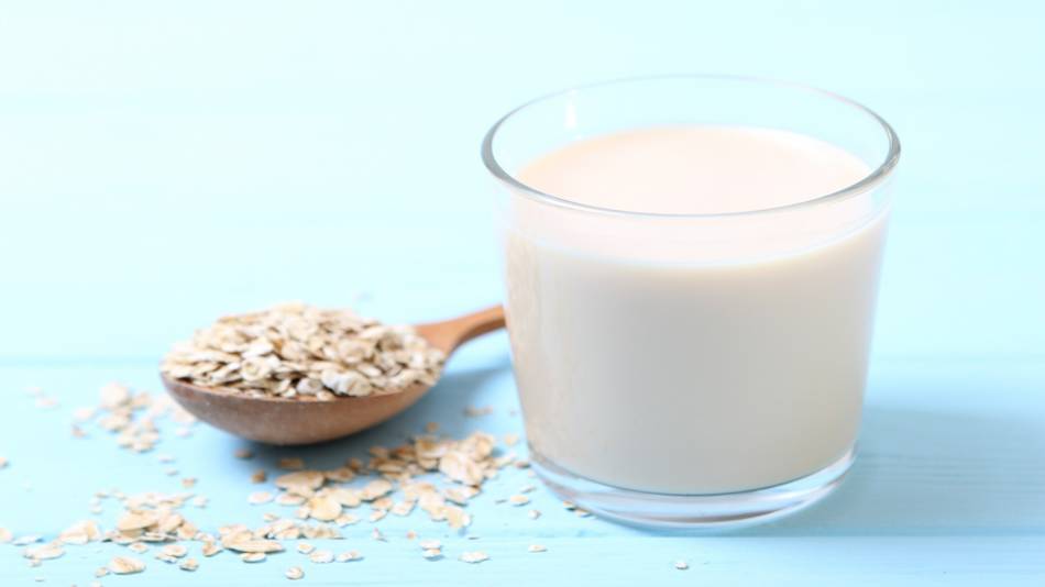 Is oatmeal milk healthy? -- glass of oatmeal milk and oats in a spoon
