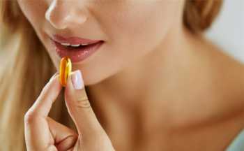 Supplements for Acne and Clear Skin -- Woman taking fish oil supplement