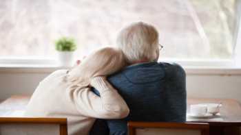 Staying Healthy During the Coronavirus Pandemic -- Couple at Home, Looking Out the Window