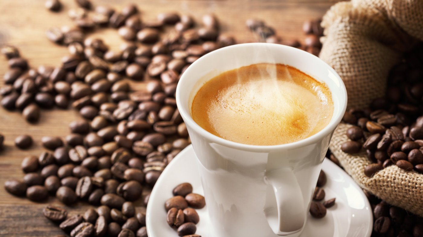 coffee cup with coffee beans on table