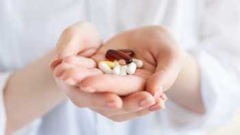 Woman holding various vitamins and supplements in her hands