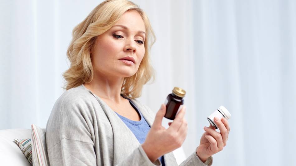 Woman with NSAID-hypersensitivity looking at two supplement containers and wondering if they are safe to take