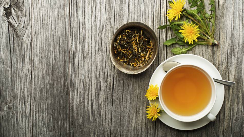A cup of dandelion root tea on wooden background