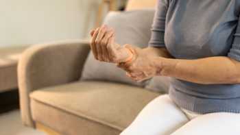 Woman holding her wrist due to joint pain