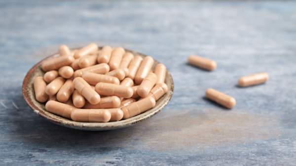 Cats claw extract capsules in a bowl on a table