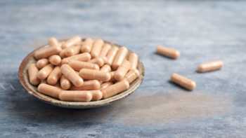 Cats claw extract capsules in a bowl on a table