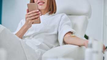 Woman holding her phone while getting an iv vitamin infusion