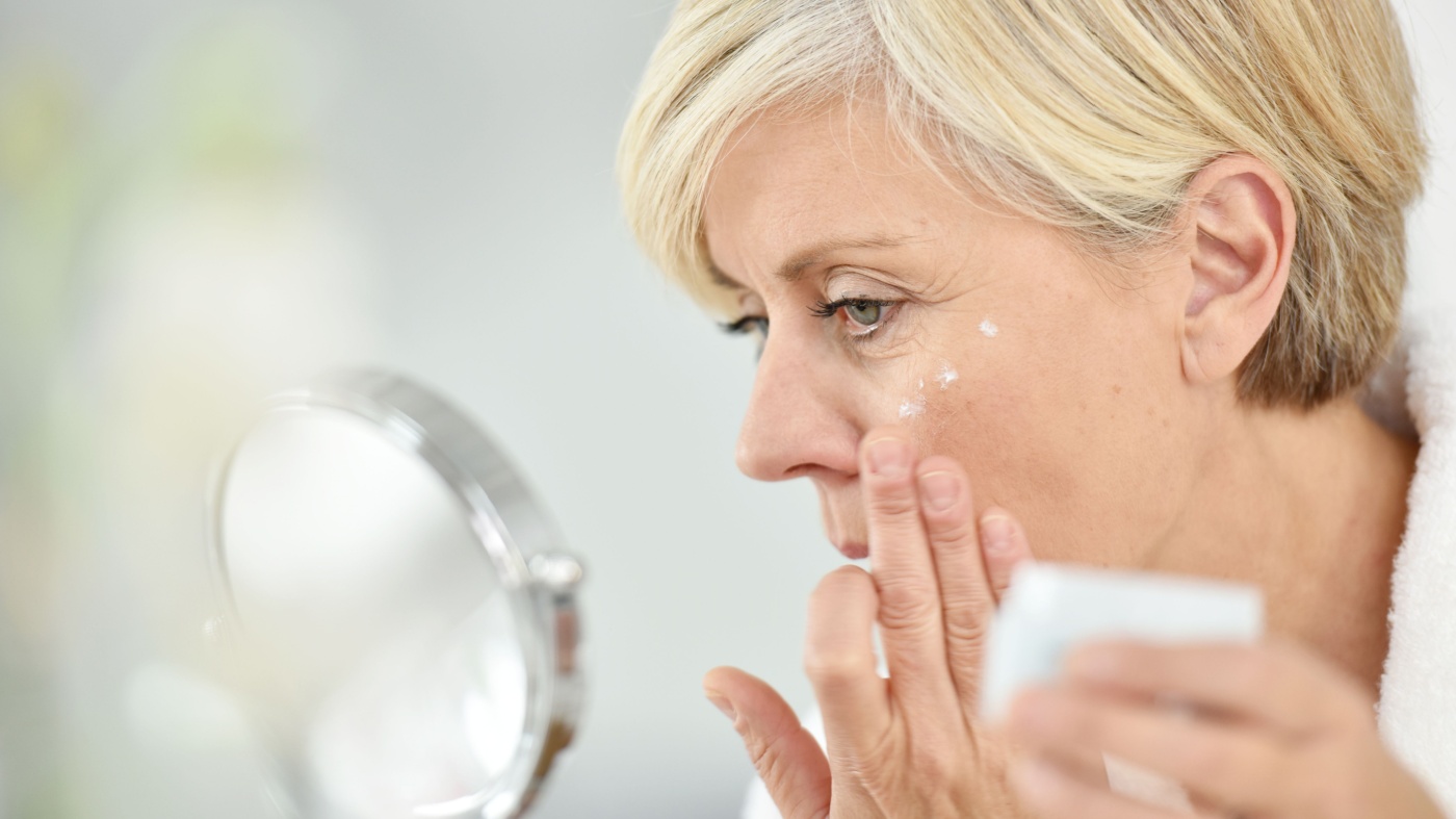 Older woman applying estriol cream for wrinkles