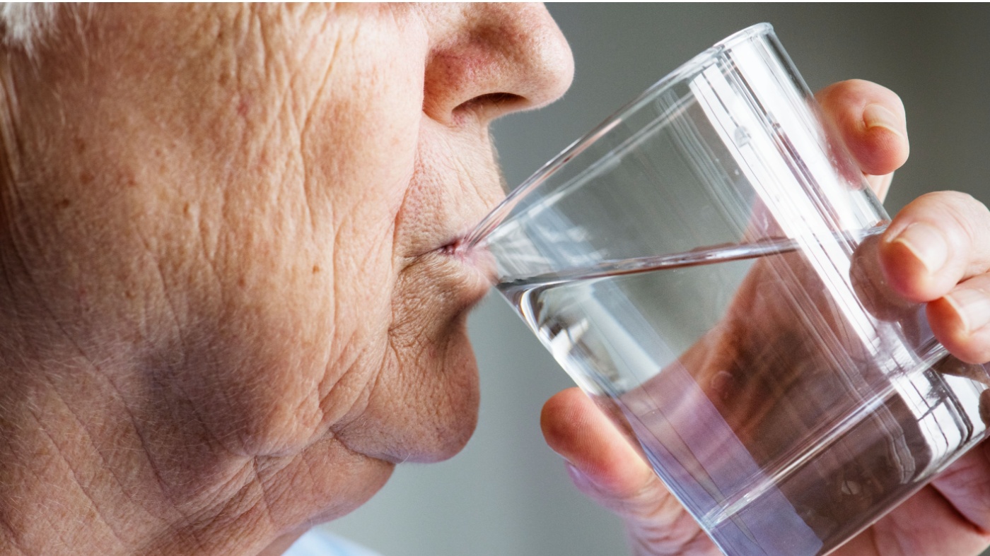 Older man drinking water for dry mouth