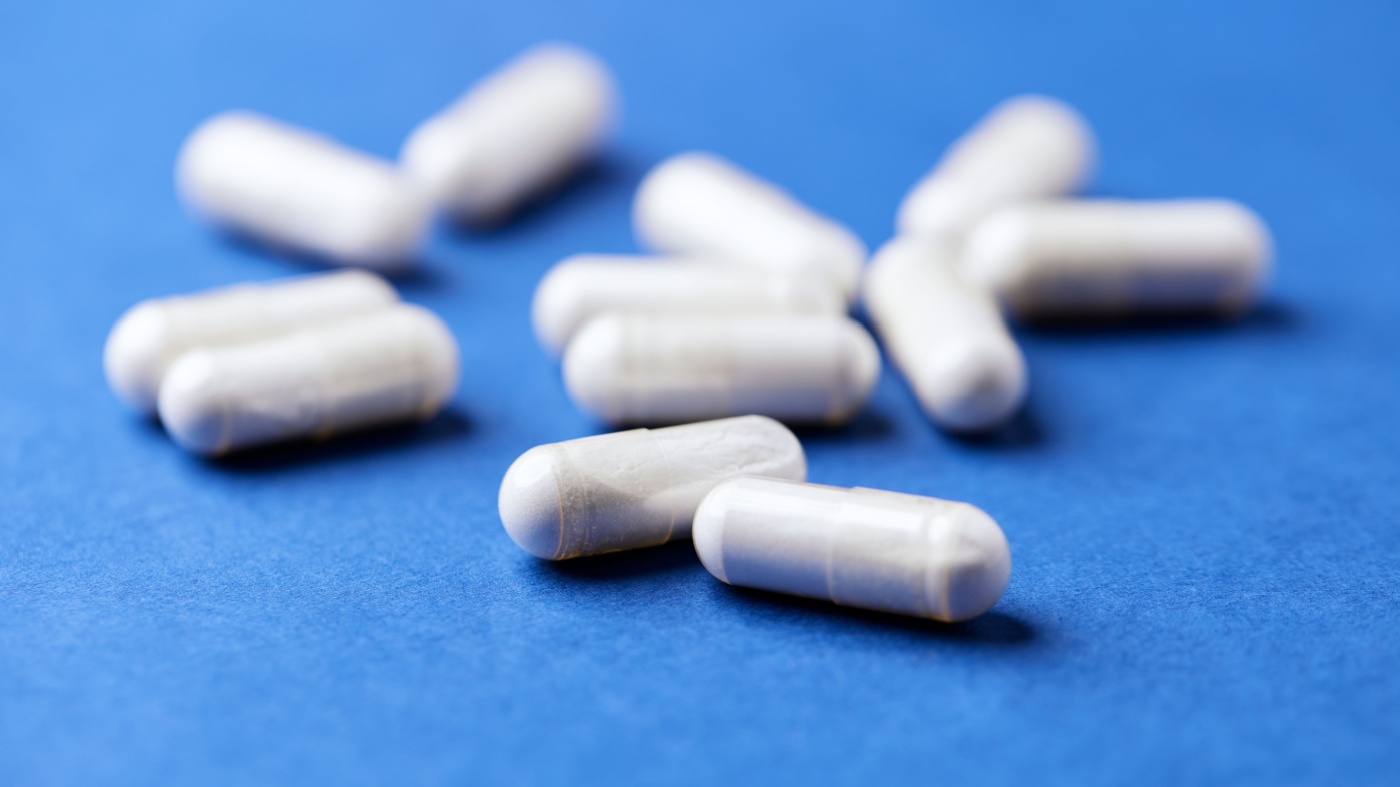 White tyrosine capsules on blue table